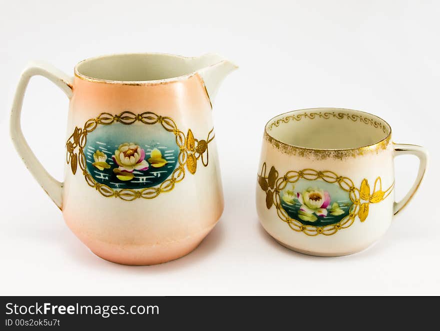 Pitcher with cup on white background