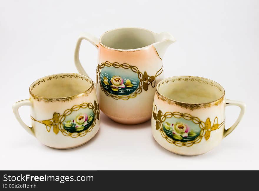 Pitcher with two cups on white background