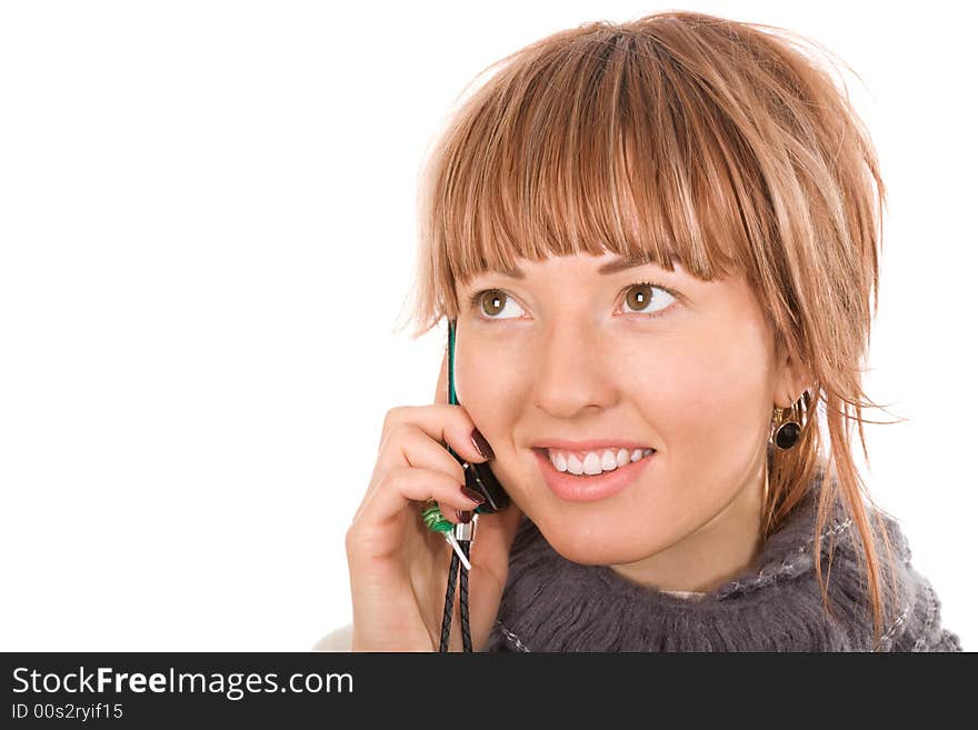 Hello! Attractive young woman call by cellular phone. On the phone hanging little trinket with  soft caramel shape