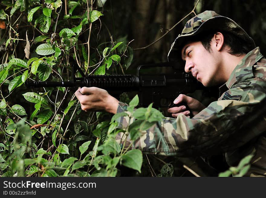 Soldier in bushes taking aim