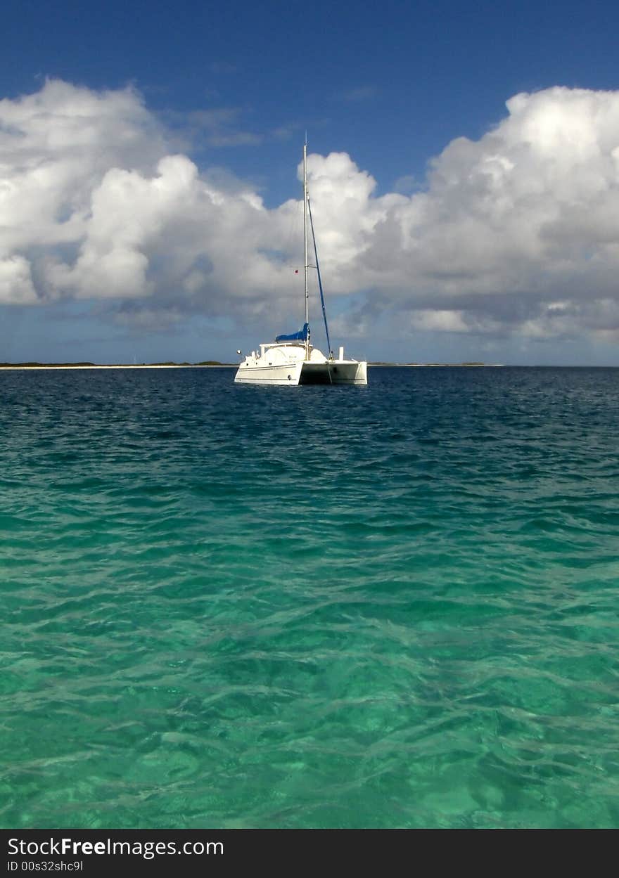 White luxury catamaran boat over blue and green sea