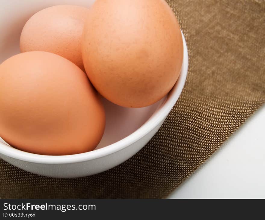 Three eggs in a white bowl