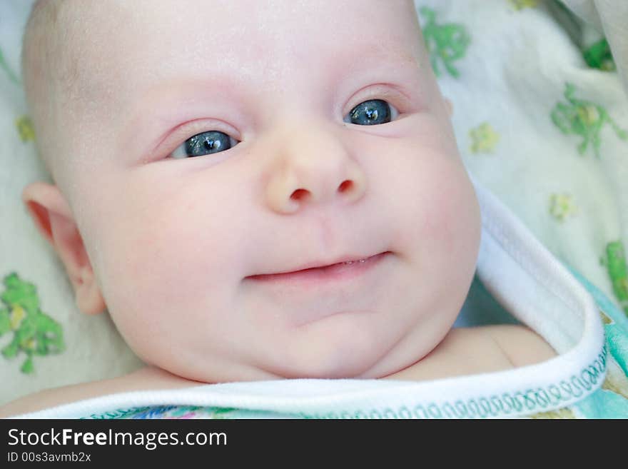 A face of a smiling baby of 2 months old. A face of a smiling baby of 2 months old