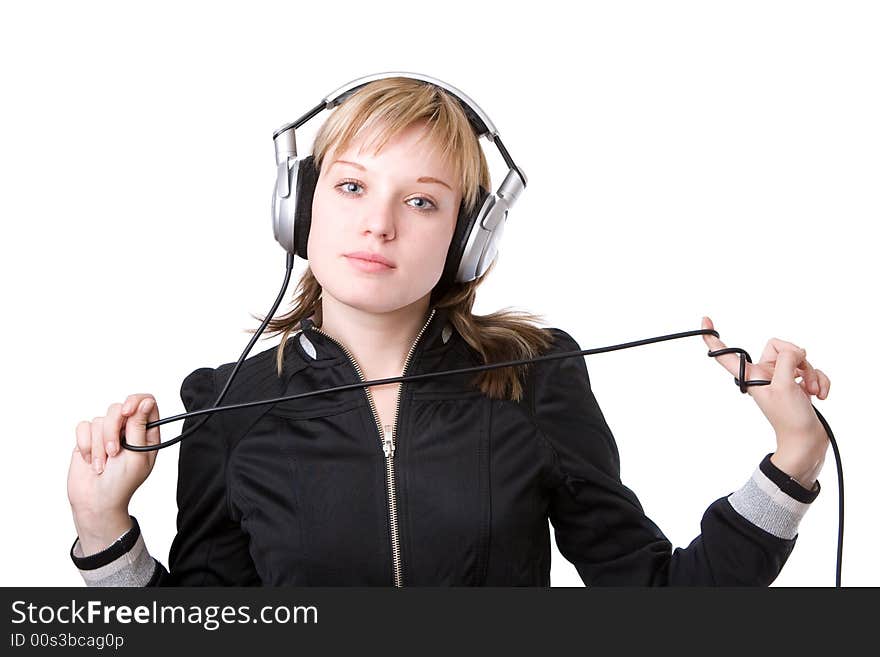 A girl plays with a cable of the earphones listening to the music. A girl plays with a cable of the earphones listening to the music