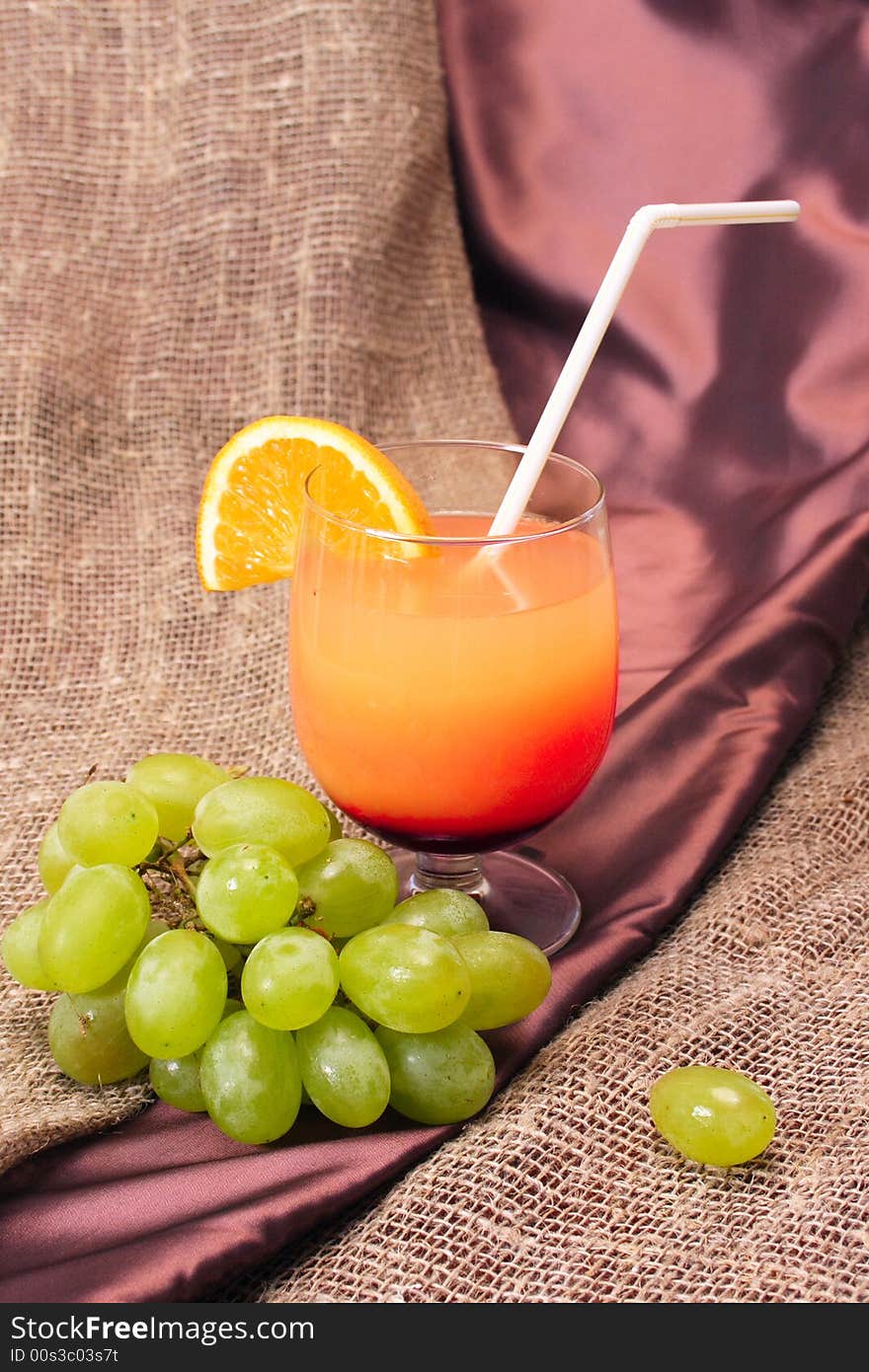 Cocktail of orange juice with a grape branch