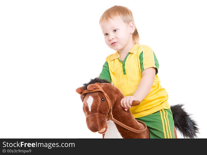 A boy of three years old riding a toy horse. A boy of three years old riding a toy horse