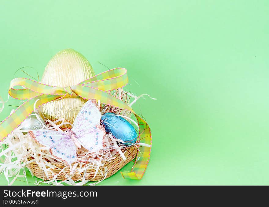 Assortment of chocolate Easter eggs wrapped in colorful paper with butterfly shot on green background. Assortment of chocolate Easter eggs wrapped in colorful paper with butterfly shot on green background