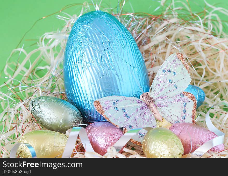 Assortment of chocolate Easter eggs wrapped in colorful paper with butterfly. Assortment of chocolate Easter eggs wrapped in colorful paper with butterfly