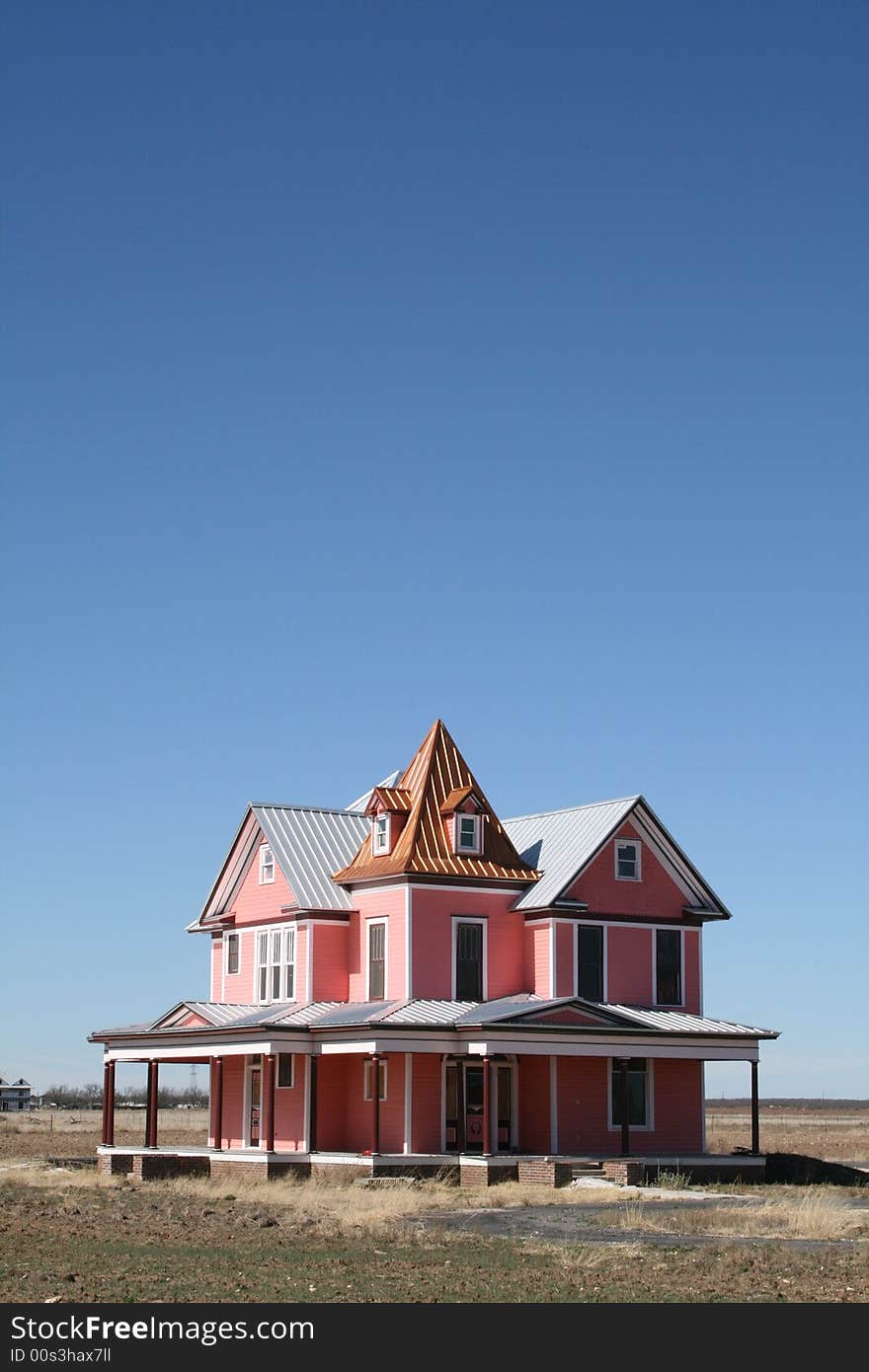 A pink Victorian style 19th century house with a clear blue sky. A pink Victorian style 19th century house with a clear blue sky.