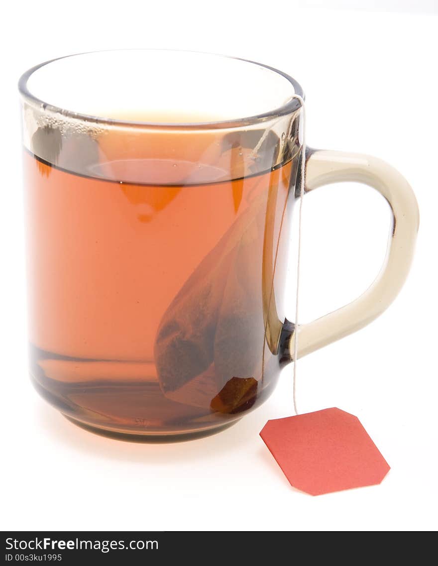 Glass teacup with  tea bag on white background