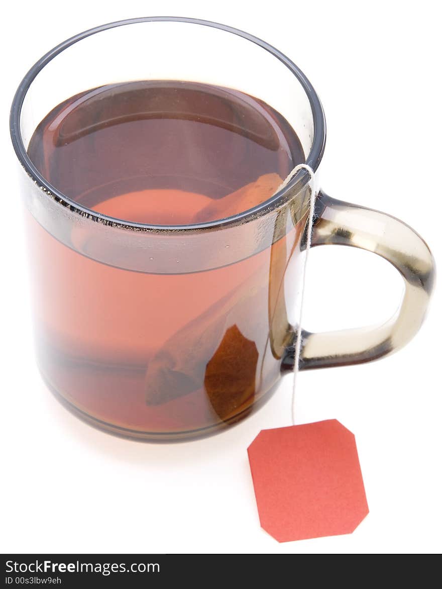 Glass teacup with  tea bag on white background