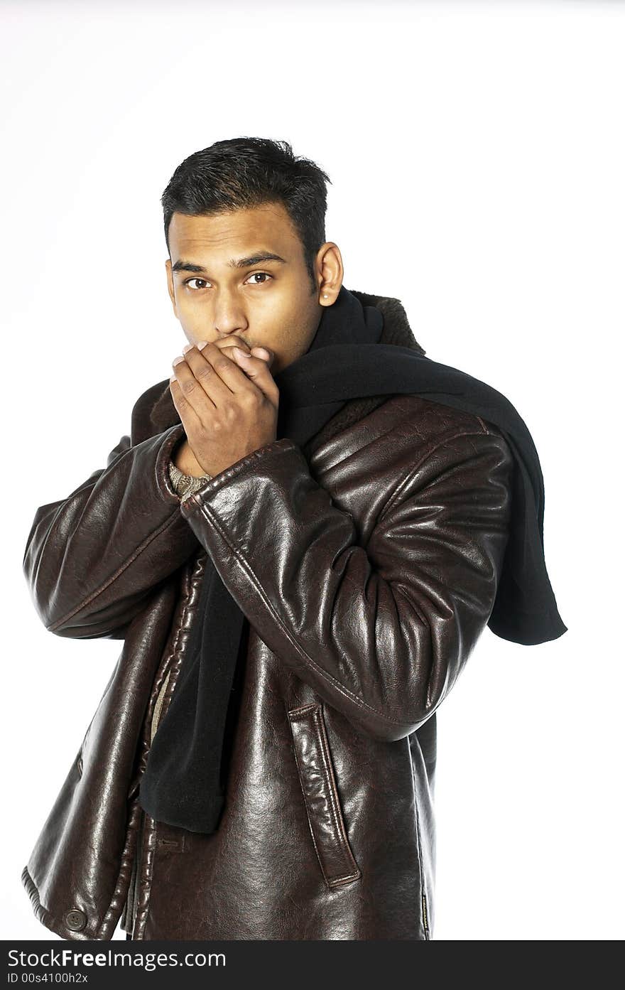 Young indian man with hands over his mouth in leather jacket and scarf. Young indian man with hands over his mouth in leather jacket and scarf