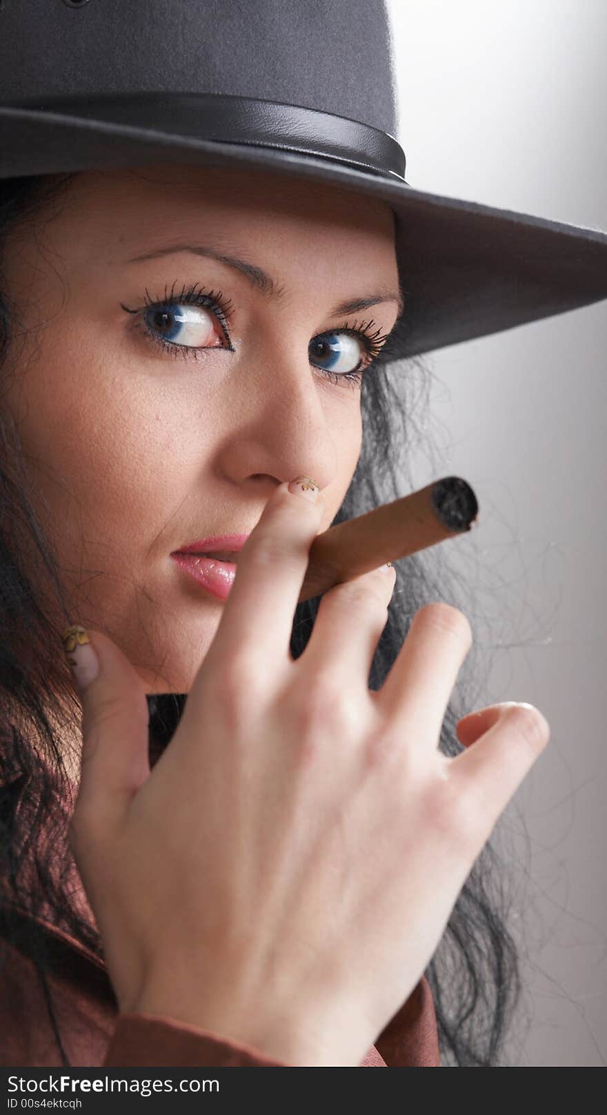 An image of a nice woman in felt hat smoking cigar. An image of a nice woman in felt hat smoking cigar