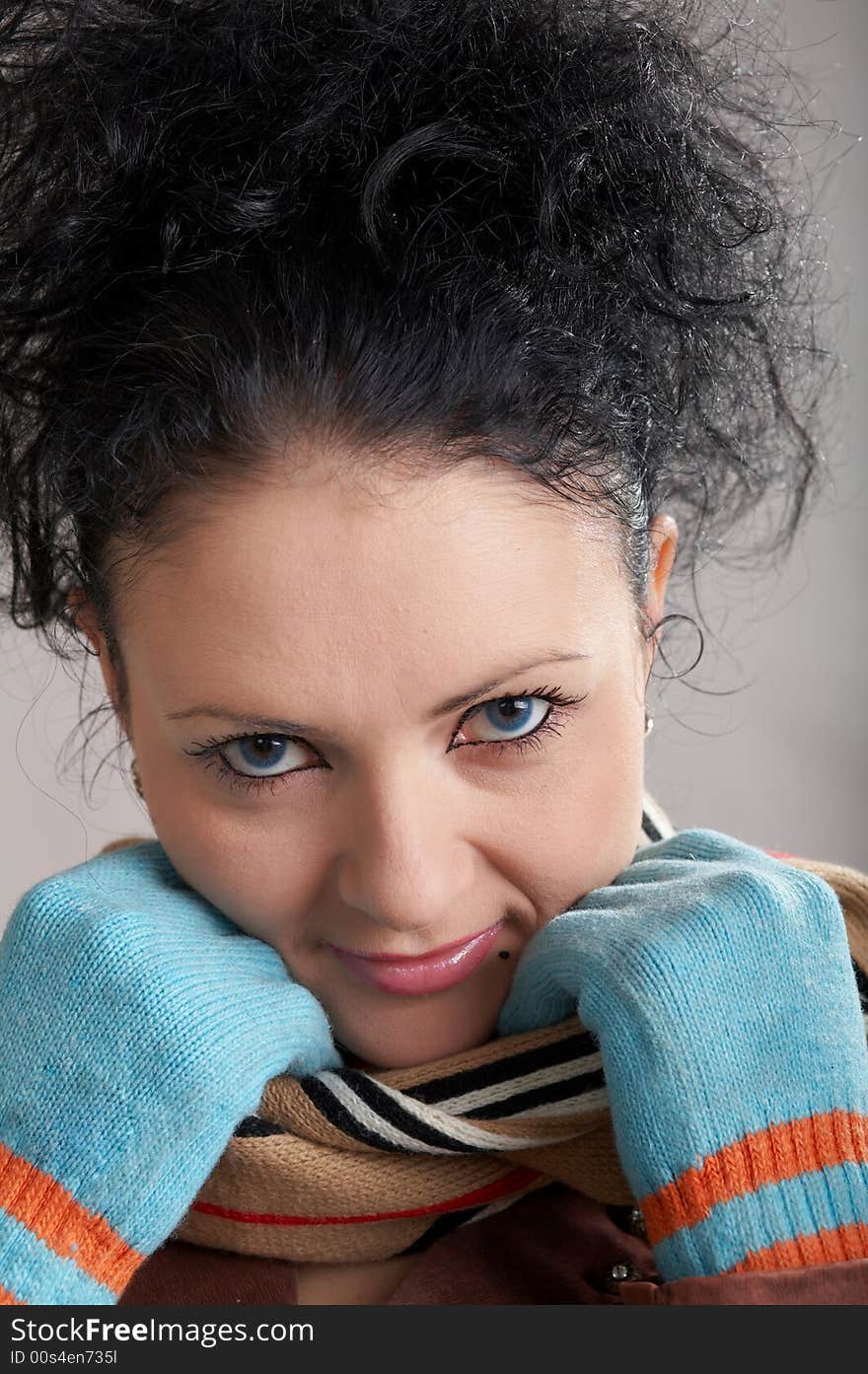 An image of a smiling girl in blue gloves