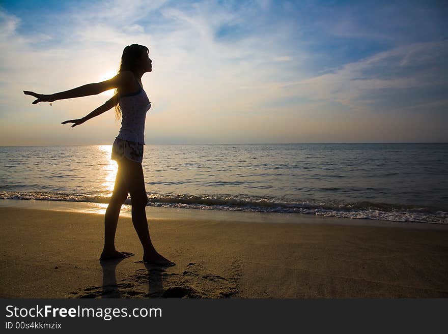 Golden silhouette of a woman doing yoga exercise at sunset. Golden silhouette of a woman doing yoga exercise at sunset