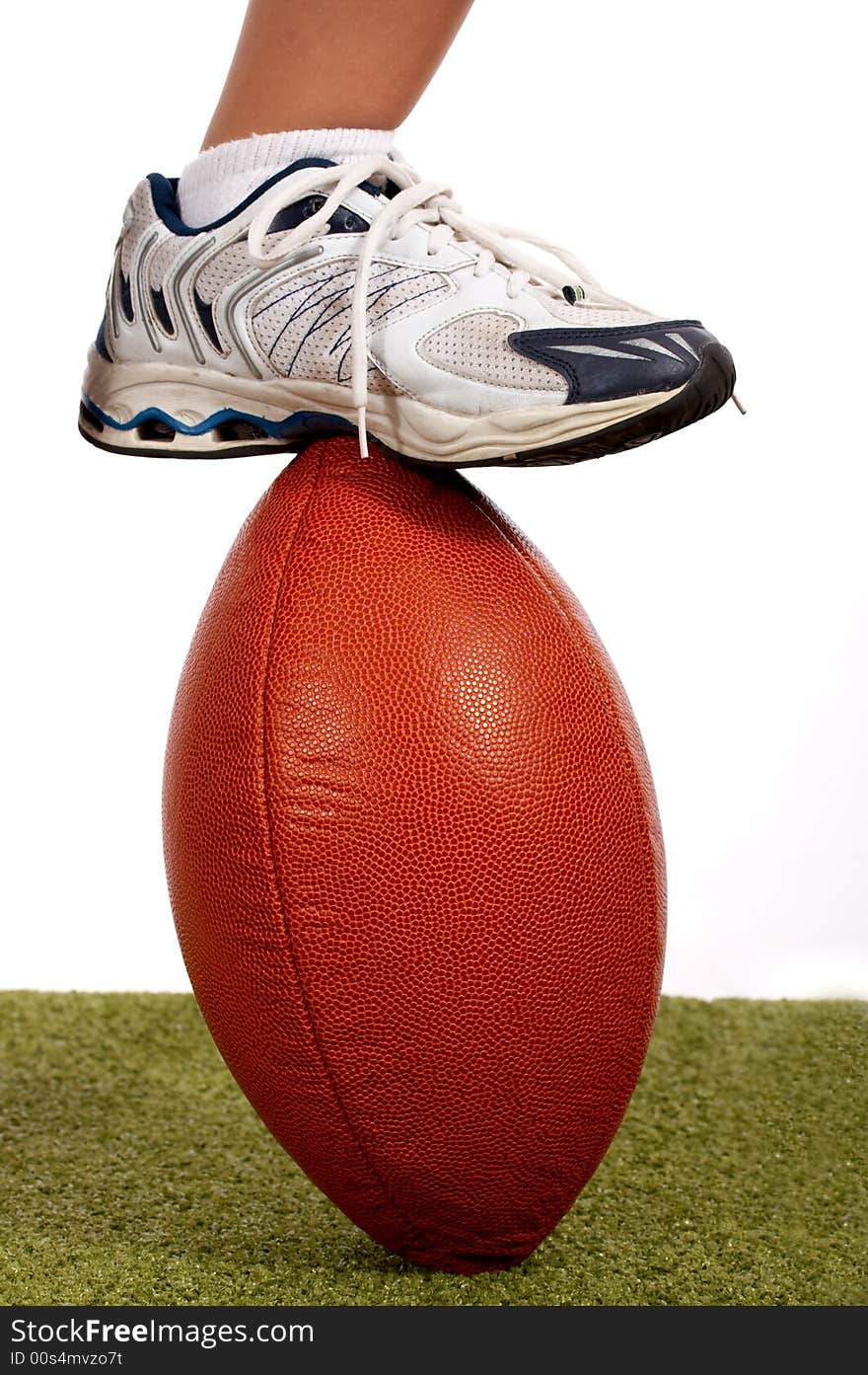 Rubber shoes stepping on a rugby ball