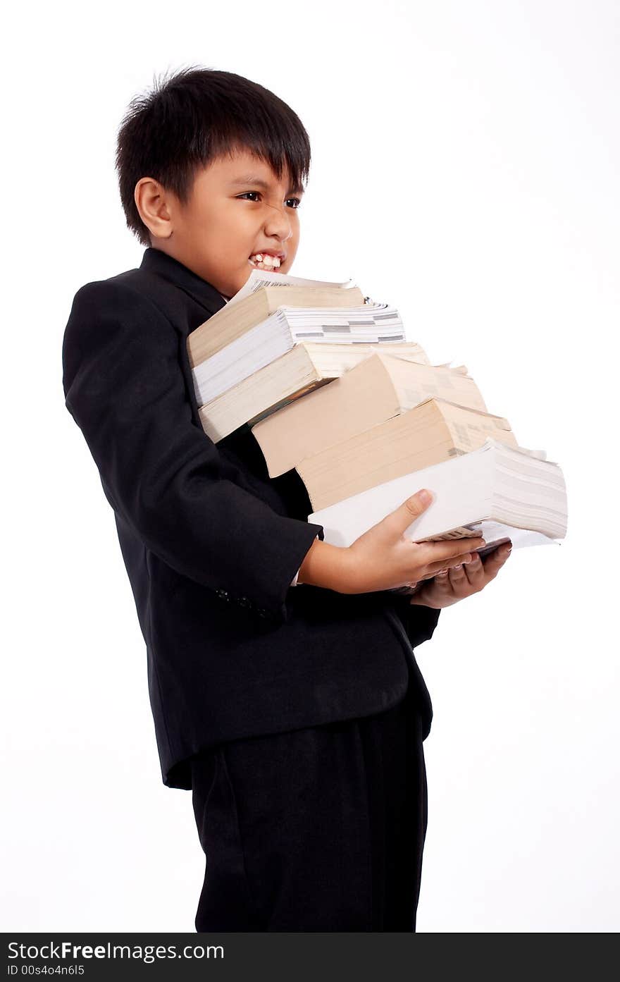 Worried young boy carrying a stack of books