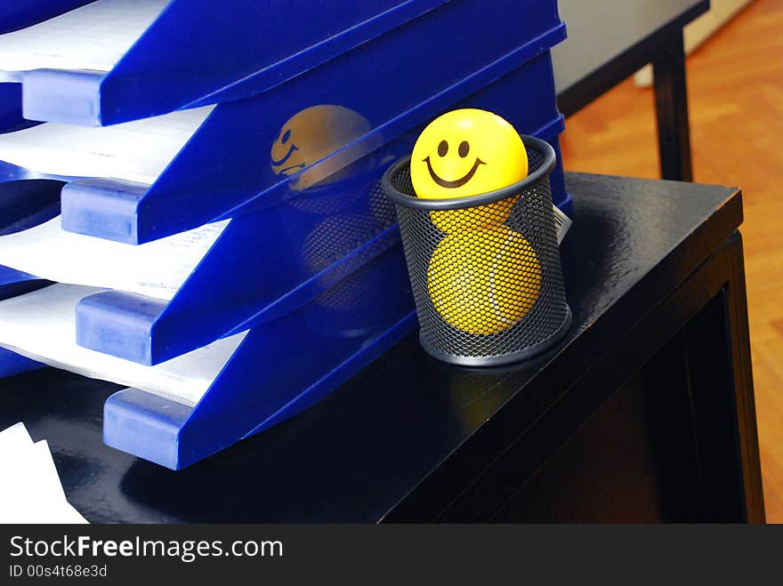 Yellow smiley ball in pen box