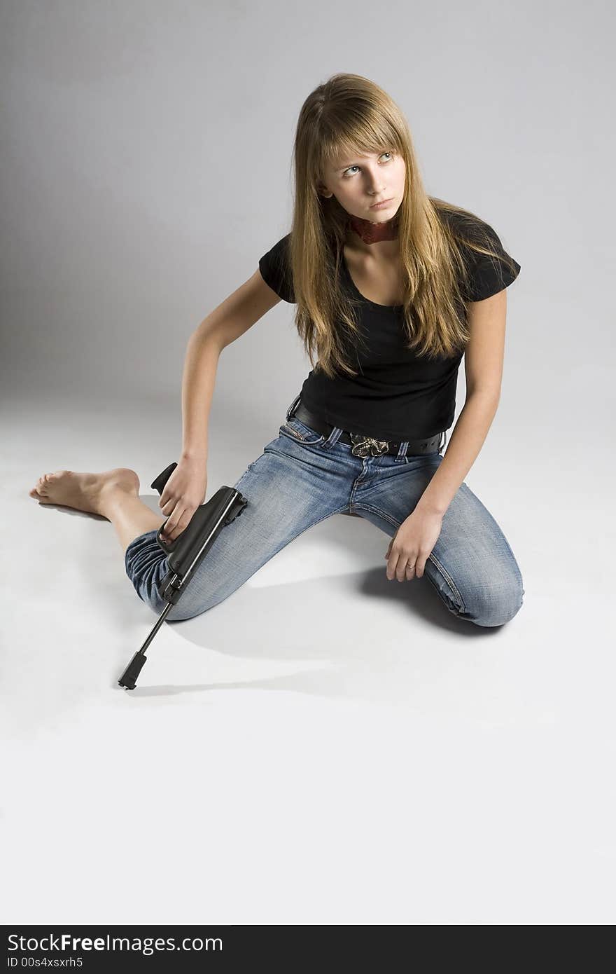 A beautiful young woman with painted neck holding a gun. A beautiful young woman with painted neck holding a gun