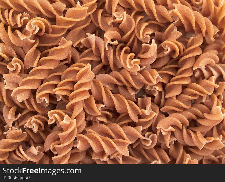 Unrefined Fusilli pasta as a background. Unrefined Fusilli pasta as a background