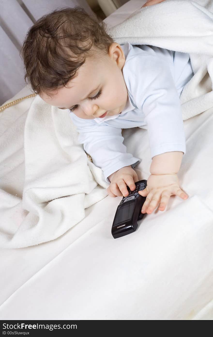 The little boy of 7 months plays with a cellular t