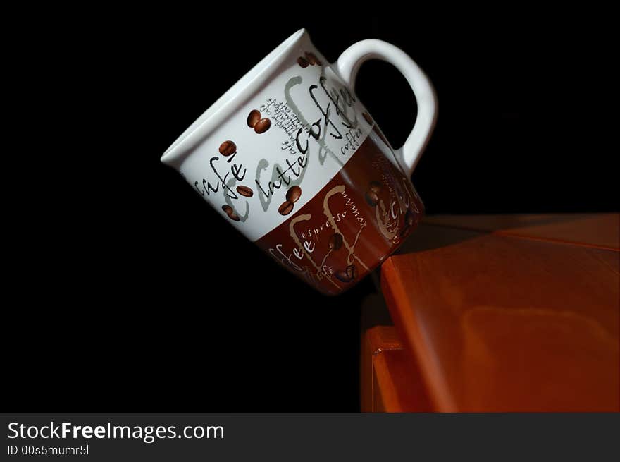 Coffee mug falling off the edge of a table. Coffee mug falling off the edge of a table