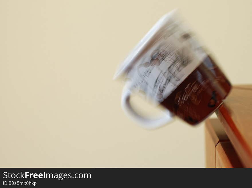 Coffee mug falling off the edge of a table. Coffee mug falling off the edge of a table