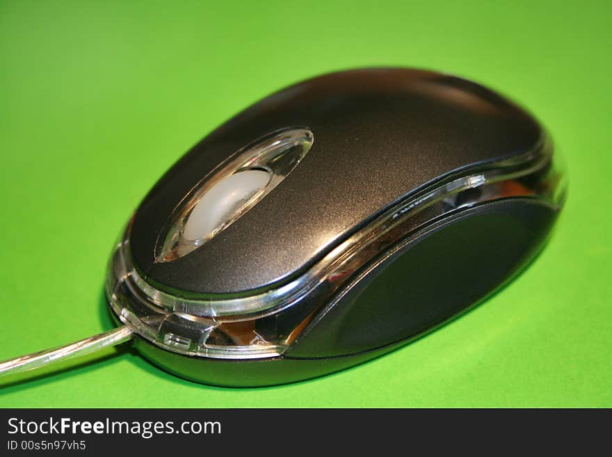 Optical computer mouse on a green background with selective focus