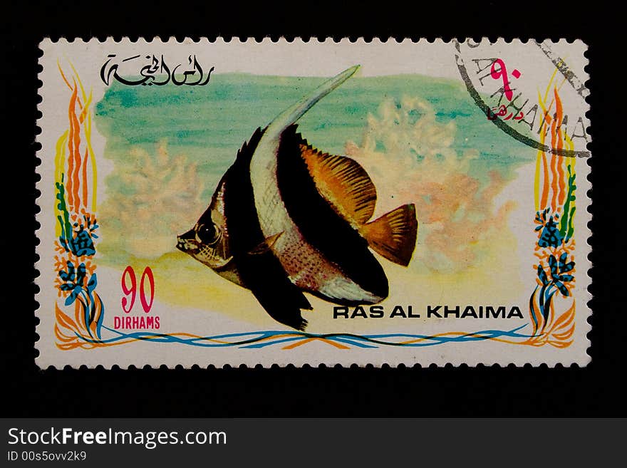 Used old stamp with fish on a black background