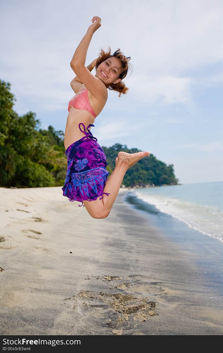 Young woman jumping happily at the beach. Young woman jumping happily at the beach