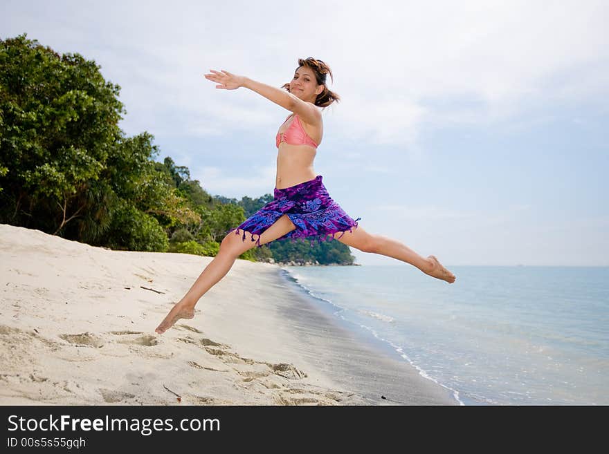 Young woman jumping happily at the beach. Young woman jumping happily at the beach