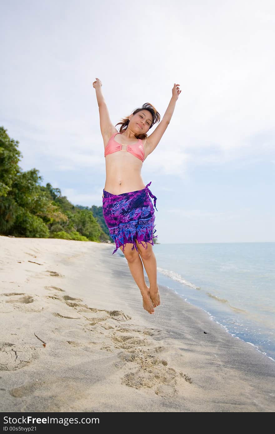 Young woman jumping happily at the beach. Young woman jumping happily at the beach