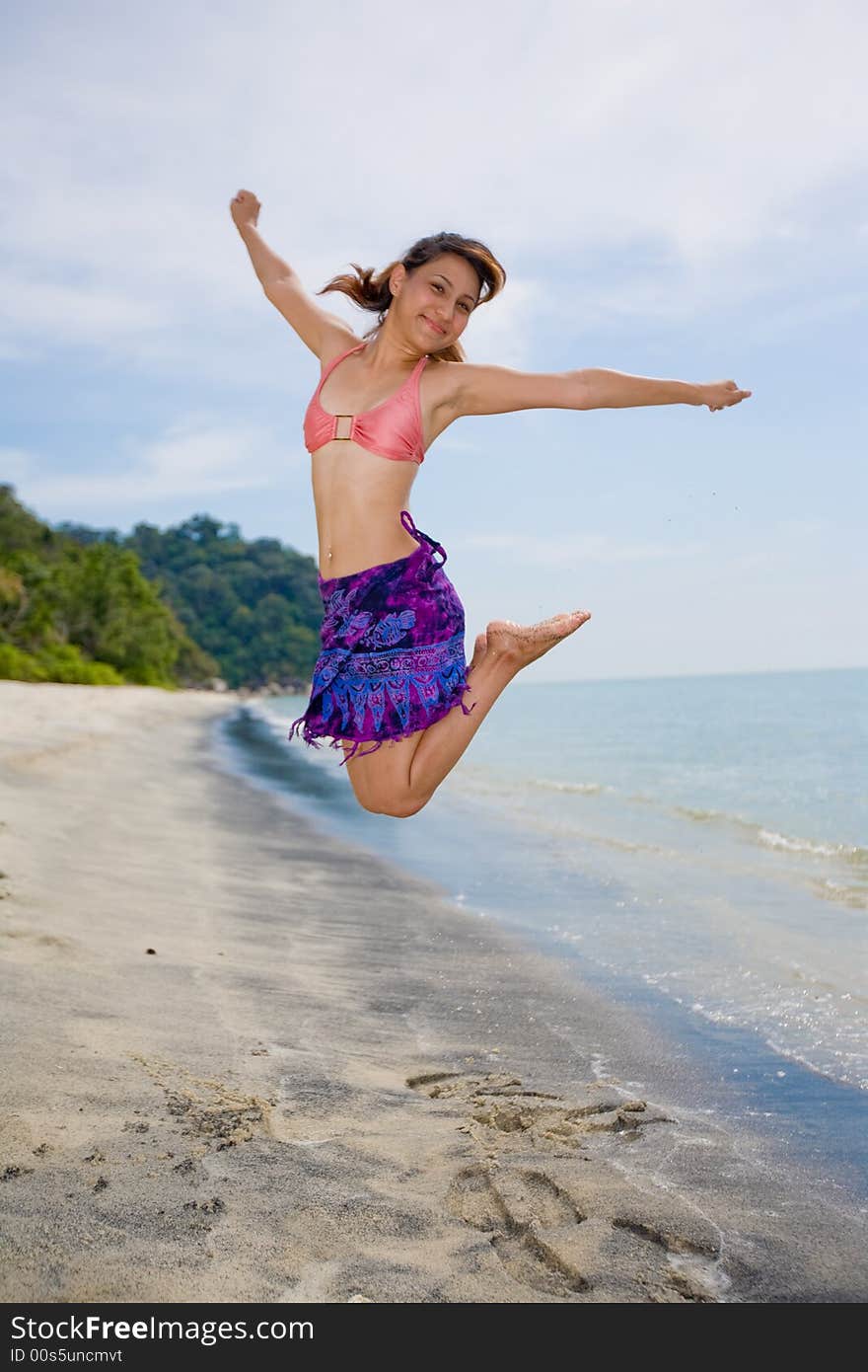 Young woman jumping happily at the beach. Young woman jumping happily at the beach