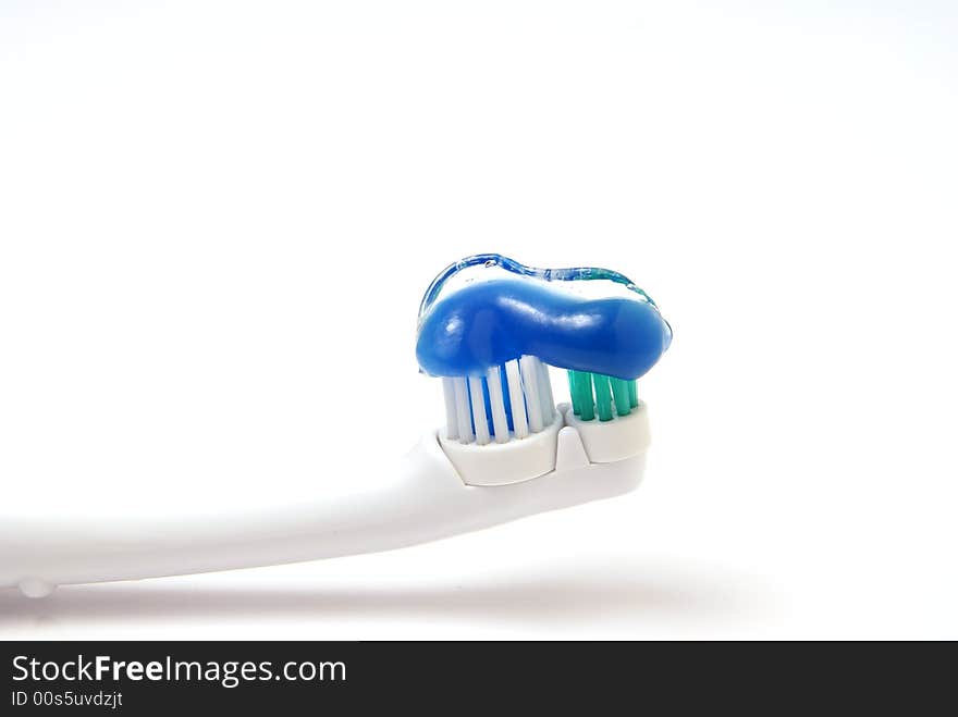 Toothbrush with clear gel toothpaste on bristles over white background. Toothbrush with clear gel toothpaste on bristles over white background