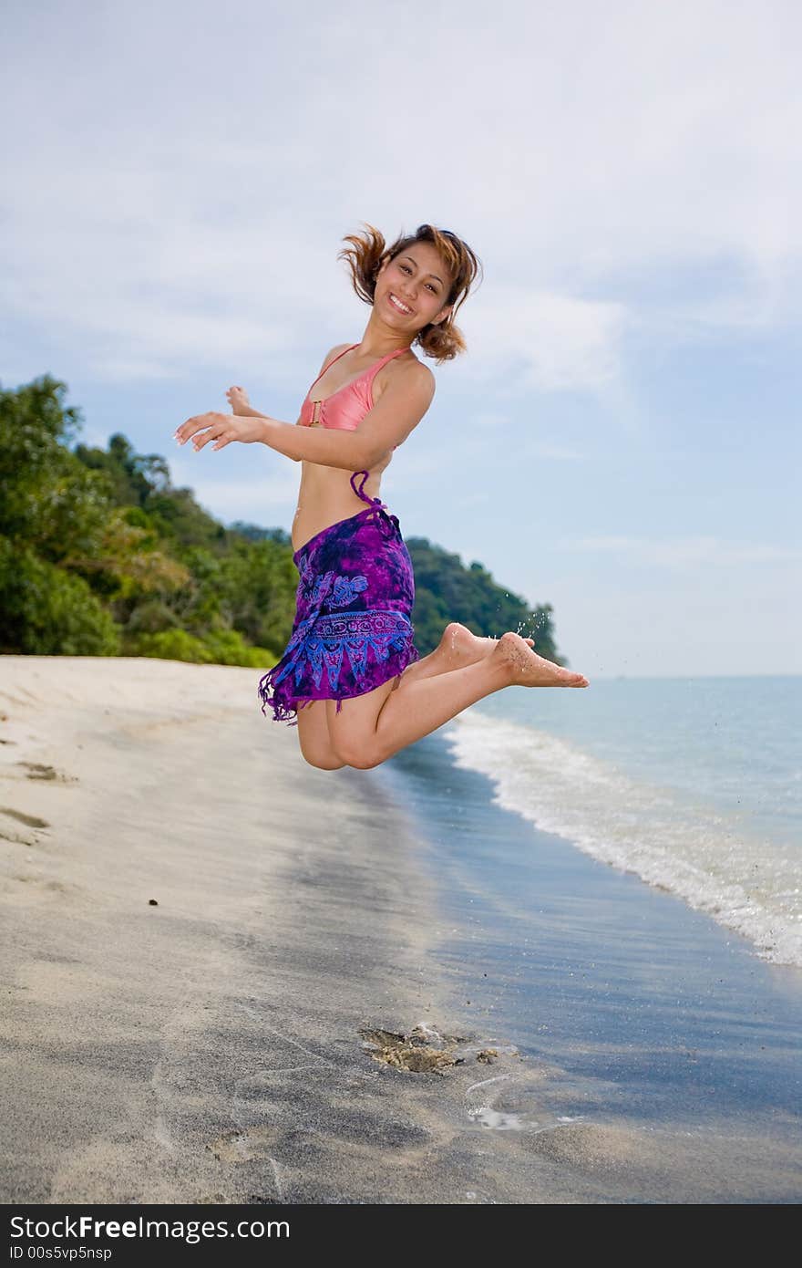 Young woman jumping happily at the beach. Young woman jumping happily at the beach