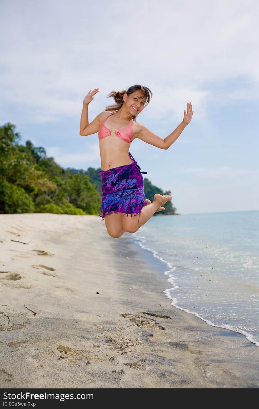 Young woman jumping happily at the beach. Young woman jumping happily at the beach