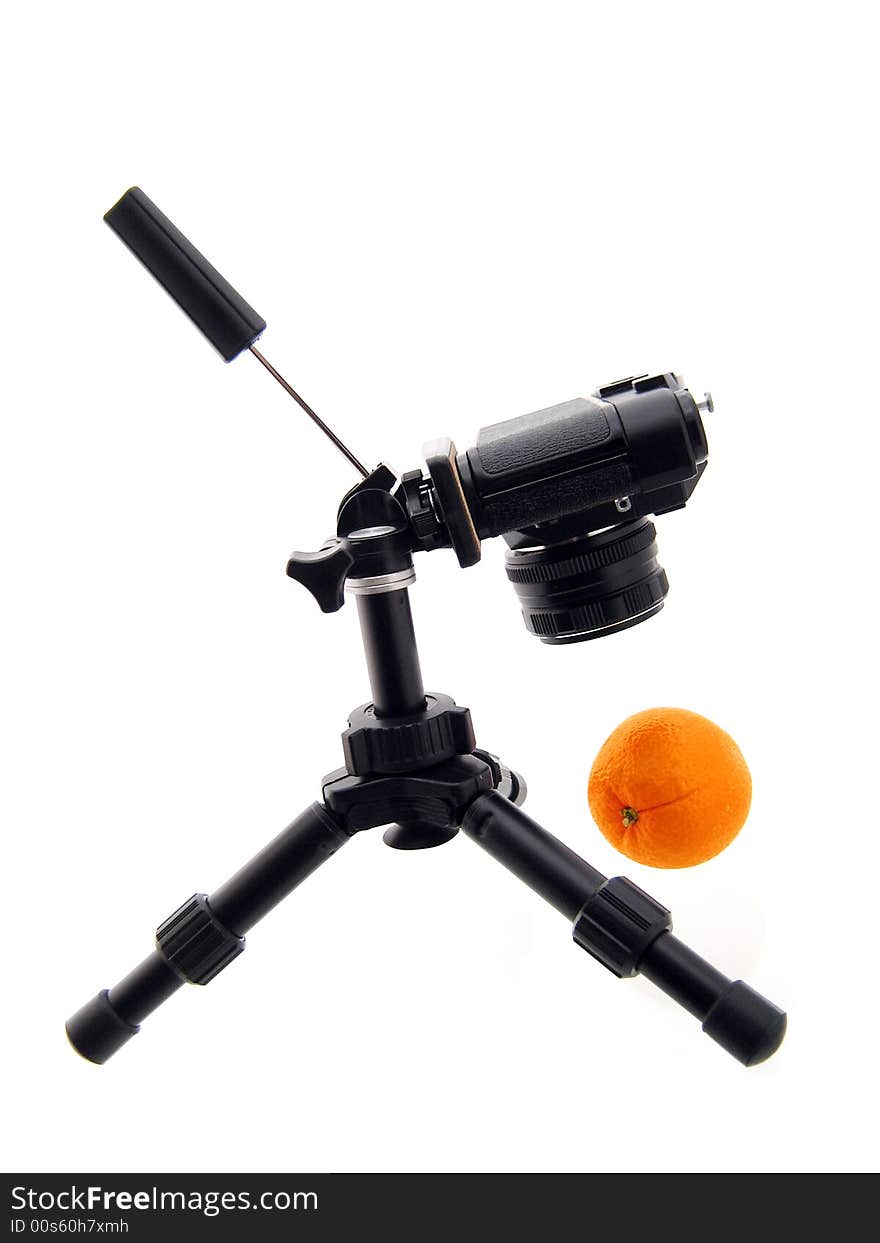 Photographing Of Orange. Black Tripod And Camera