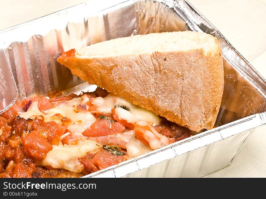 Carry out meal chicken parmesan with a slice of bread in the carry out container. Carry out meal chicken parmesan with a slice of bread in the carry out container