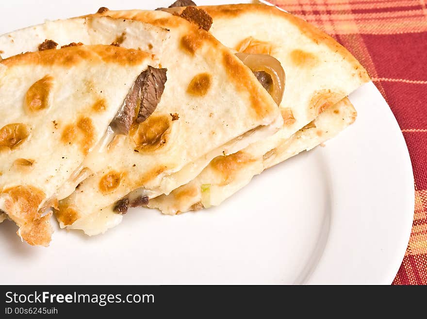 Fresh off the stove a steak Quesadilla on a white plate