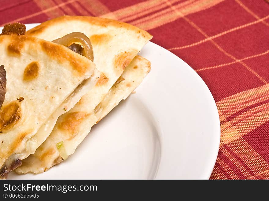 Fresh off the stove a steak Quesadilla on a white plate