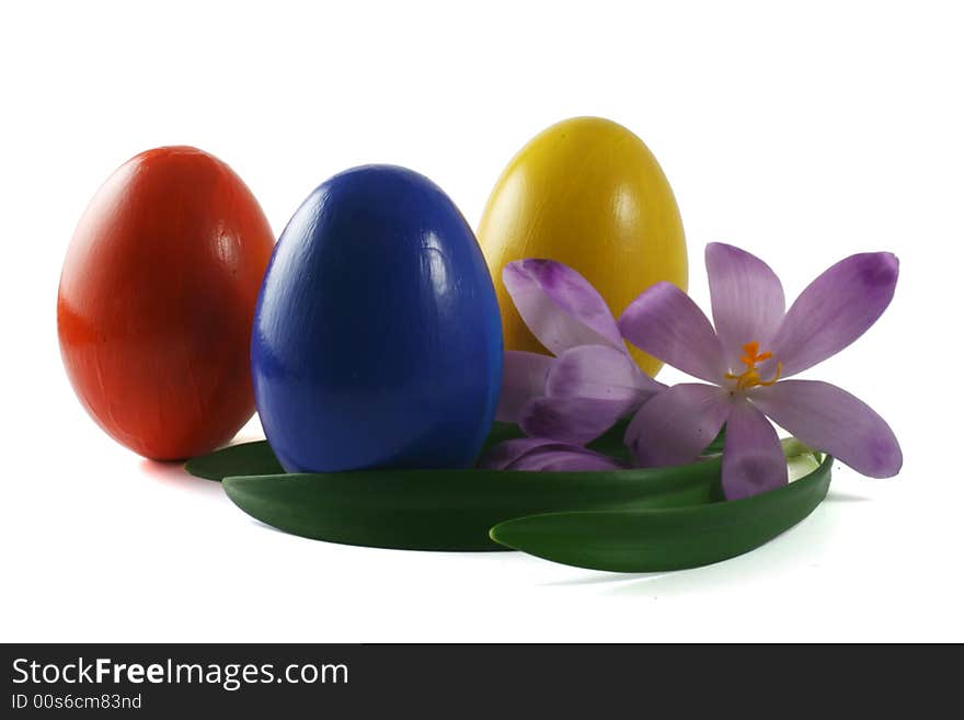 Three coloured eggs with spring flowers isolated on white. Three coloured eggs with spring flowers isolated on white