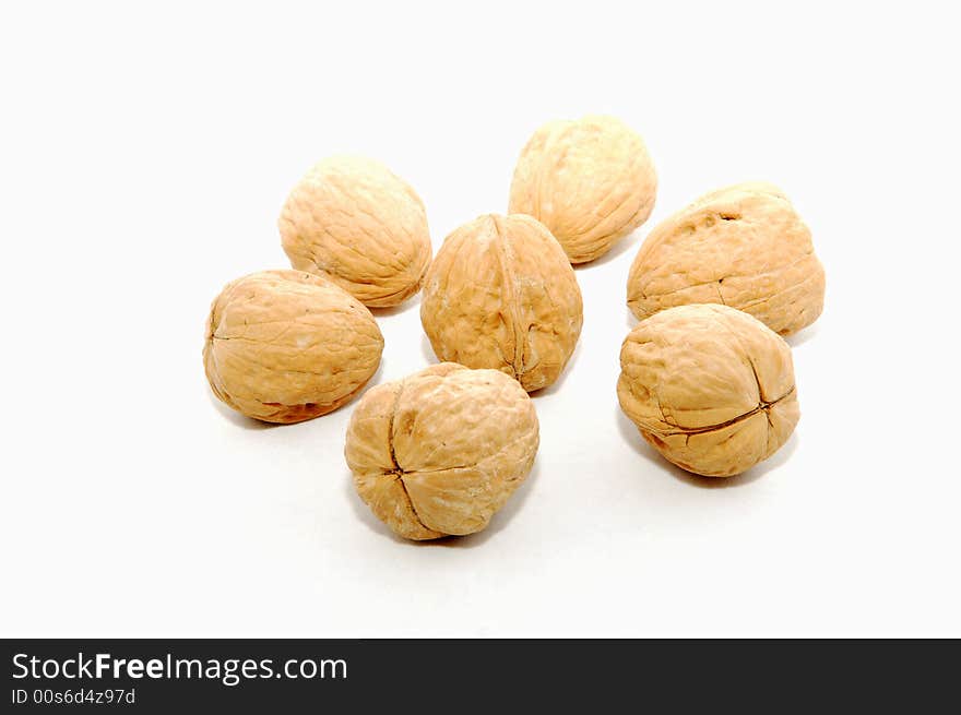 Seven walnuts over white.