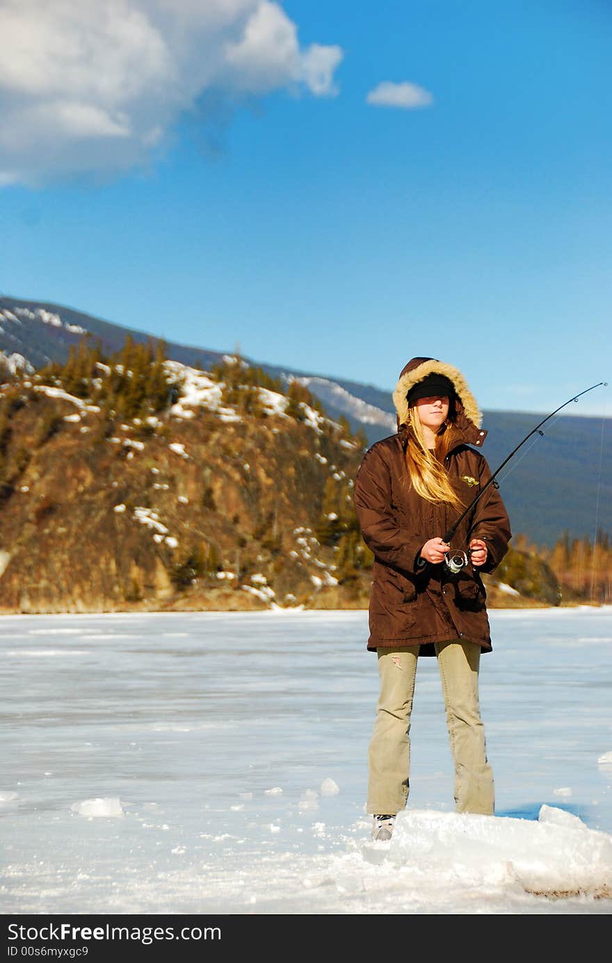 Young blonde girl is skating on a frozen lake