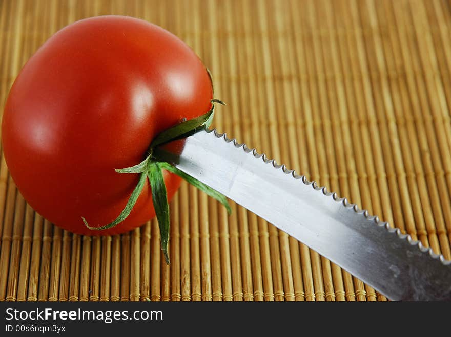 a fresh red tomatoes with a knife