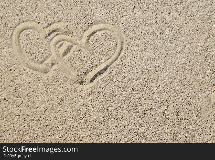 Two hearts painted on sand can be used as background. Two hearts painted on sand can be used as background