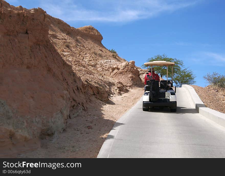 Man driving golf cart on desert course