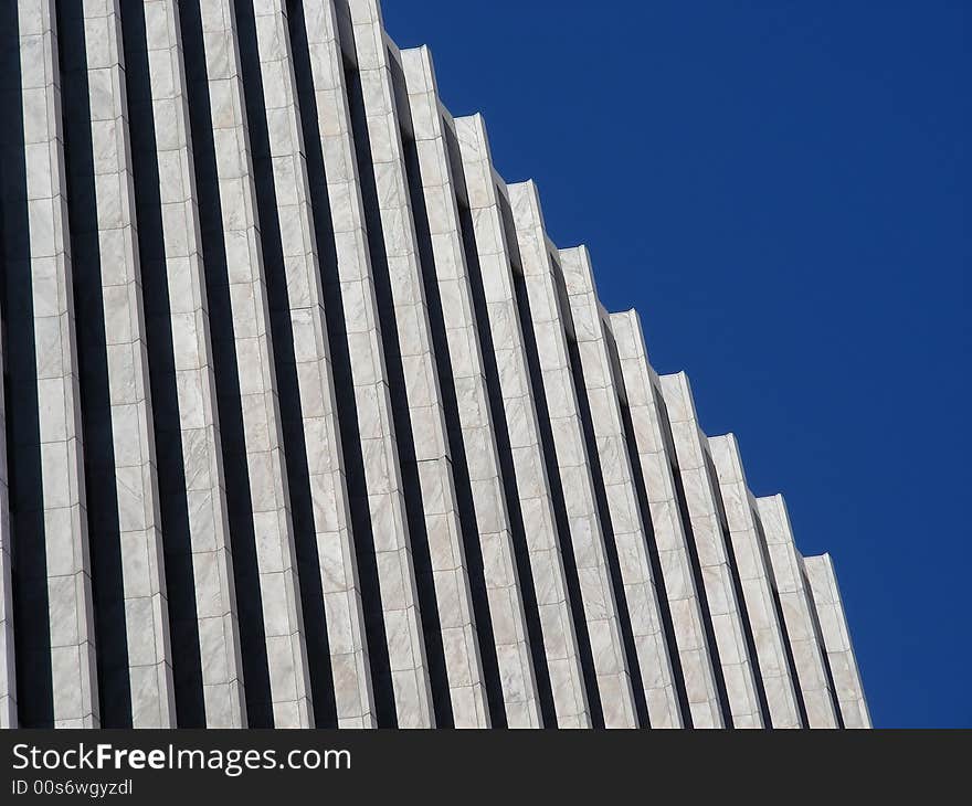 A repeating pattern of black and white columns against a blue sky.