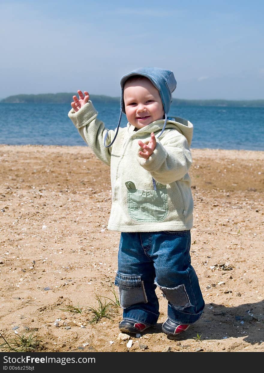 Happy smiling kid walking on the seaside beach. Happy smiling kid walking on the seaside beach