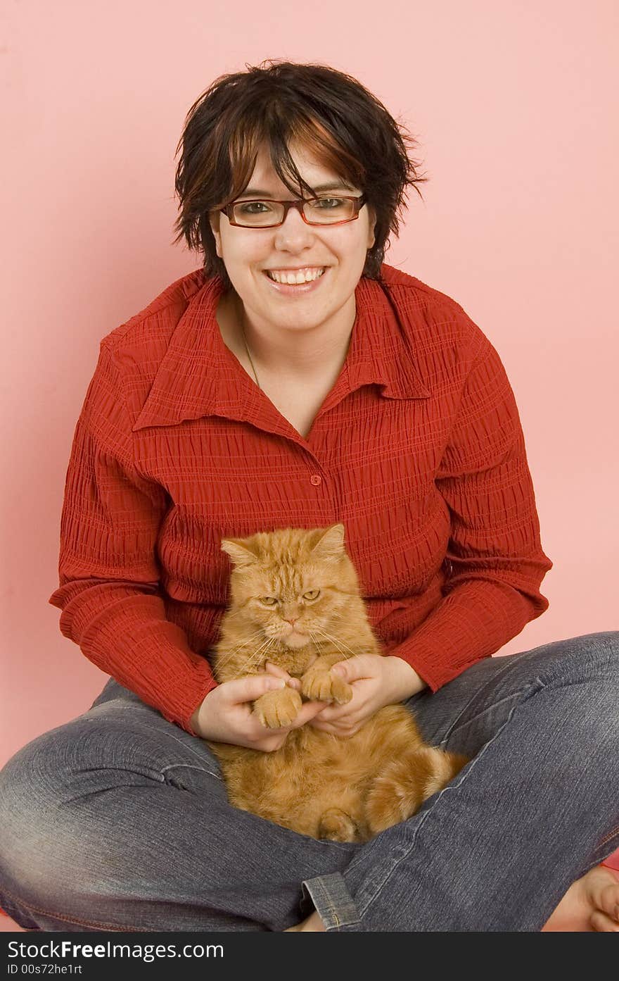 Young beautiful woman holds a domestic red cat