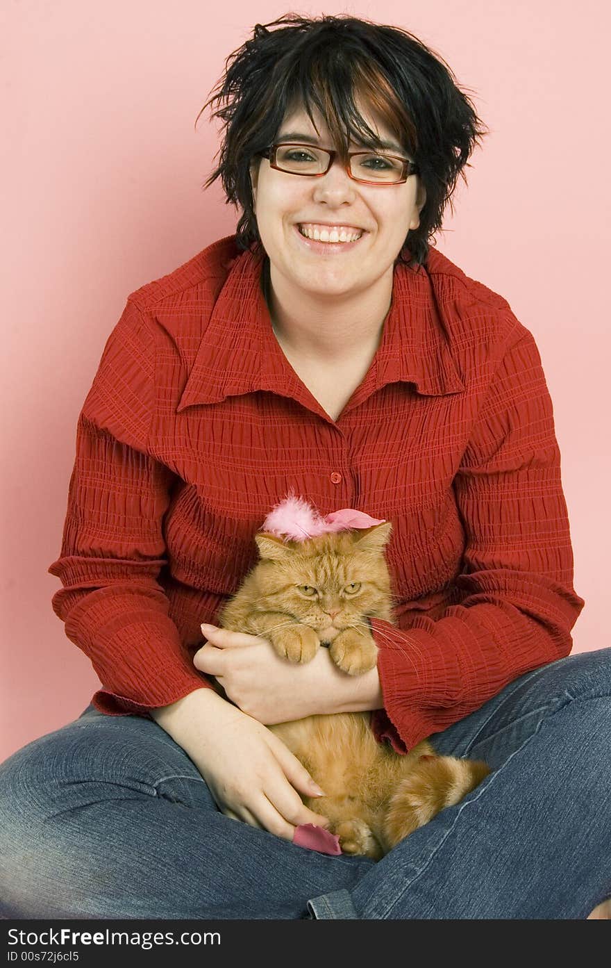 Young beautiful woman holding a red domestic cat